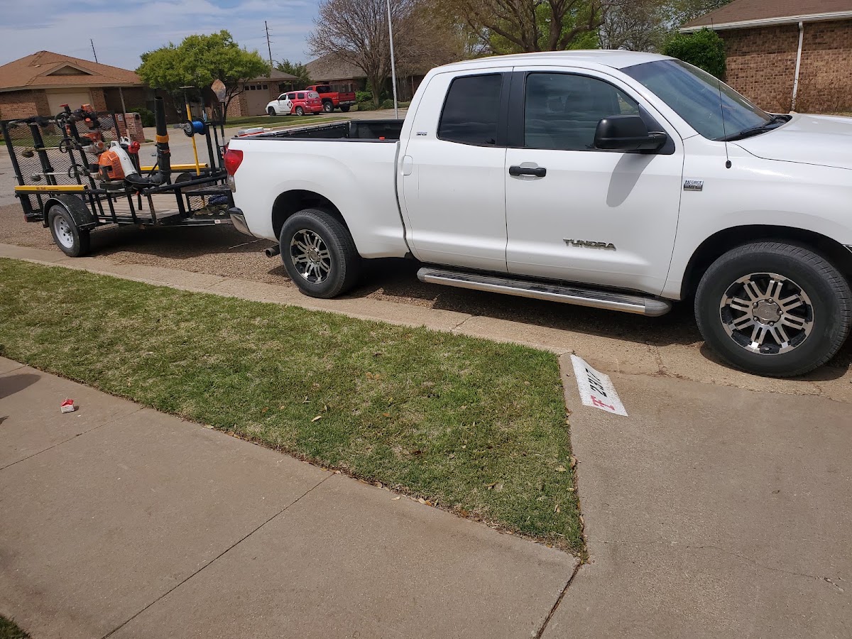 Rangel's pickup and equipment trailer at a job