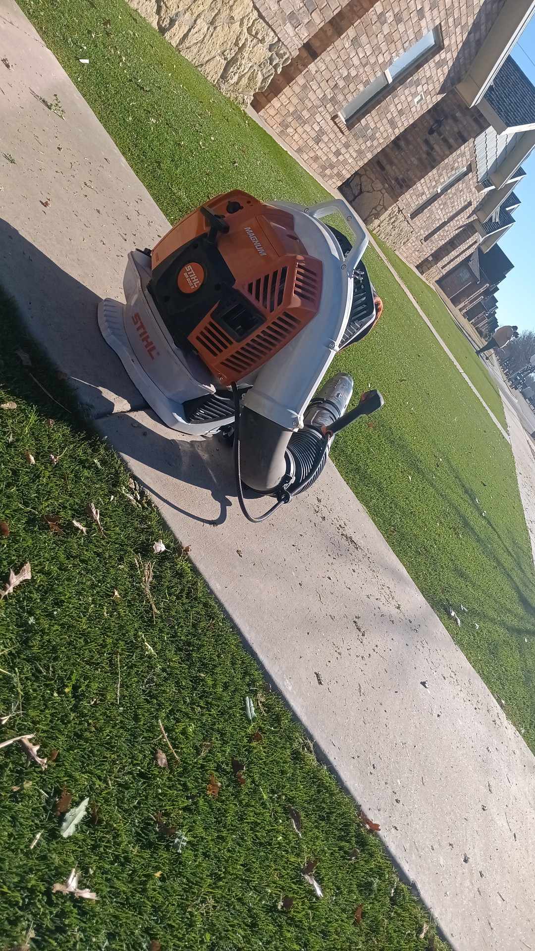 Leaf blower clearing a sidewalk edge